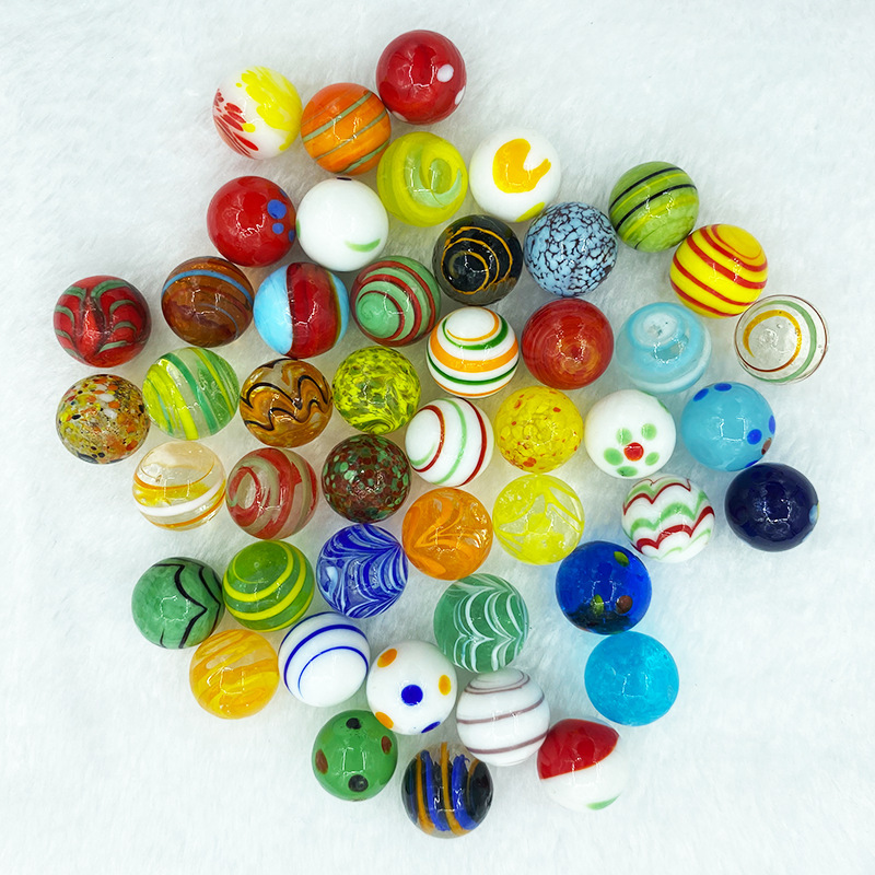 Mixed group of round decorative marbles on a white surface
